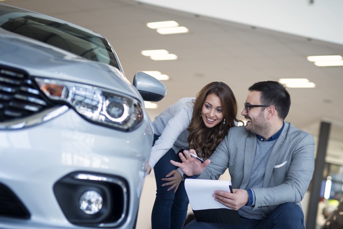 professional car salesman and buyer talking about car specs and price.